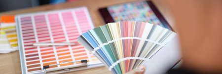 Designer advises his client to choose color from different samples in design studio.の写真素材