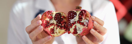 Female nutritionist show pomegranate as important source of vitamins, antioxidants and microelementsの写真素材