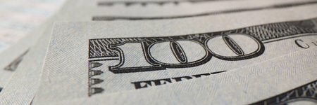 Paper banknotes of one hundred dollars accumulating in bank