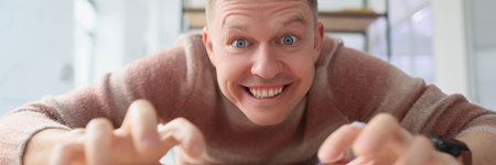 Crazy man types on keyboard with fingers looking with smileの写真素材