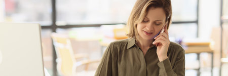 Woman listens to client on phone making notes with penの写真素材