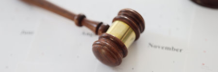 Wooden judge gavel and sound block lie on calendar paperの写真素材