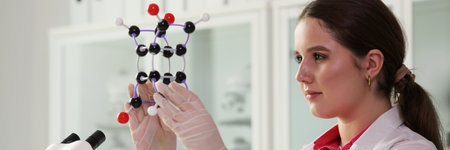 Laboratory worker in white coat examines model of molecule
