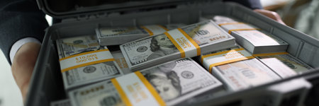 Manager holds case with counted stacks of dollar banknotes
