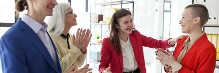 Colleagues applaud greeting lady worker success in officeの写真素材