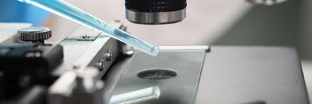 Scientist examines blue reagent under electronic microscope