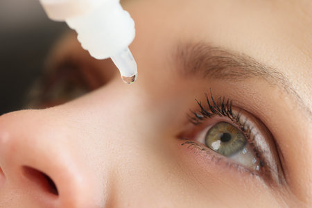 Close-up of woman applying medical eye drops against diseases.の写真素材