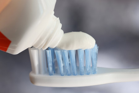 Squeezing white toothpaste onto toothbrush.の写真素材