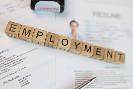 Word employment collected from wooden cubes on employee resume with stamp and pen.の写真素材