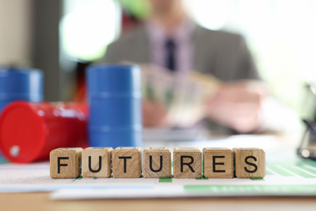 Word futures collected from wooden cubes with oil barrels and blurred business person in background.