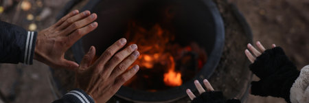 Male and female travelers warming hands near bonfireの写真素材