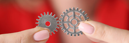 Woman hands holding and connecting metal gearsの写真素材
