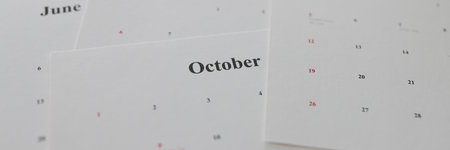 Calendar papers with marked dates lying on tableの写真素材