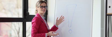 Smiling woman near presentation board showing exclamation pointの写真素材