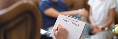 Male psychologist holding clipboard with family therapy notes sheetの写真素材