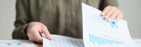 Manager checkups papers with business statistics in officeの写真素材