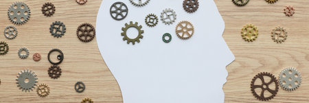 Paper human head with small cogwheels on wooden surfaceの写真素材