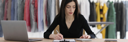 Manager counts on calculator writing at dry cleaning tableの写真素材