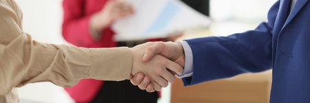 Business partners shake hands after good deal in officeの写真素材