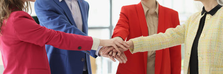 Happy business team members join hands celebrating dealの写真素材