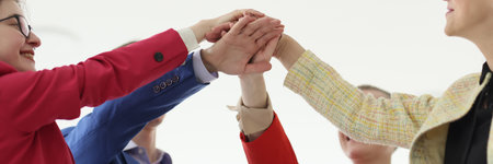 Happy businesspeople join hands during teambuilding trainingの写真素材