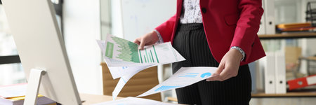 Female accountant in pink jacket does paperwork in premiseの写真素材