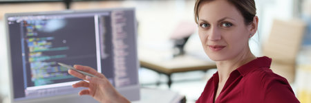 Woman shows with pen on complex code developing softwareの写真素材