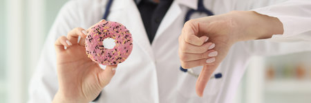 Nutritionist shows sign of disapproval holding pink donutの写真素材