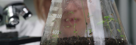 Focused scientist holds glass flask with cannabis plantの写真素材