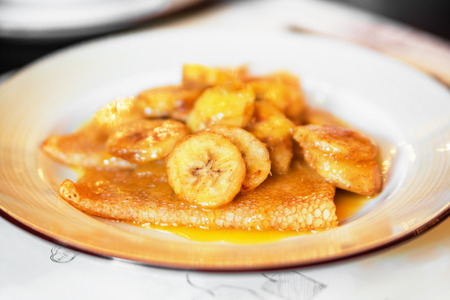 Caramelised banana and pancake dessert on a plateの写真素材