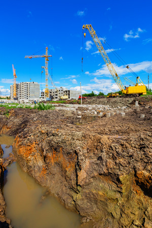 Cranes on the construction site beneath blue cloudy skyの写真素材