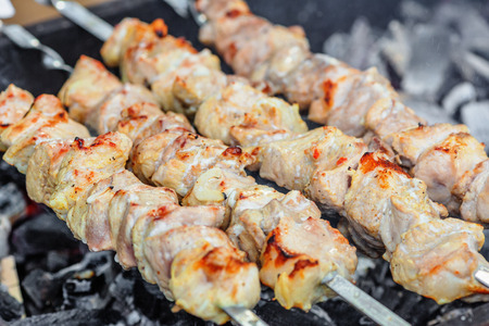 Shish kebab being roasted on skewers over charcoalの写真素材
