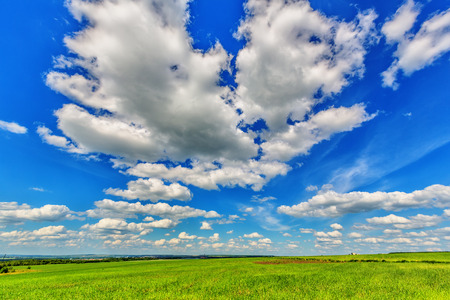 Blue sky with cumulus clouds over the plainの写真素材