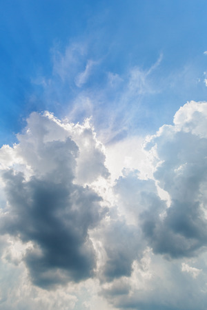 Background of blue cloudy sky with sun raysの写真素材