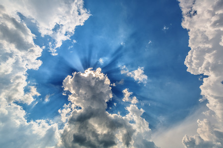 Background of blue cloudy sky with sun rays