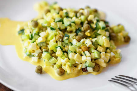 Traditional russian mayonnaise salad with eggs on white plateの写真素材