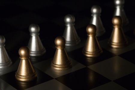 number two pawns on a chess board facing each other (light brush)の写真素材