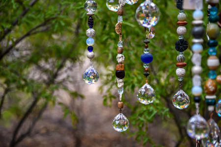 Beaded artwork hanging among trees at craft fairの写真素材