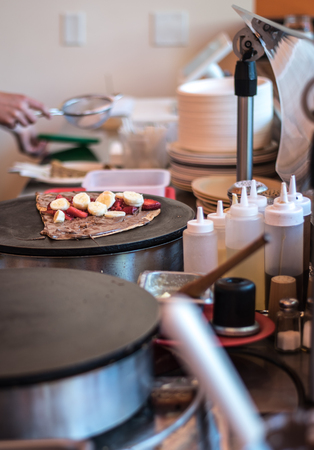 Crepe being made with strawberries, chocolate, and bananasの写真素材