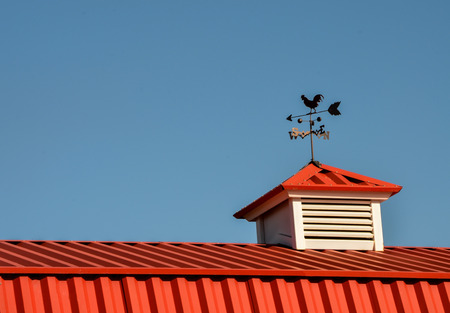 Red barn with rooster weathervaneの写真素材