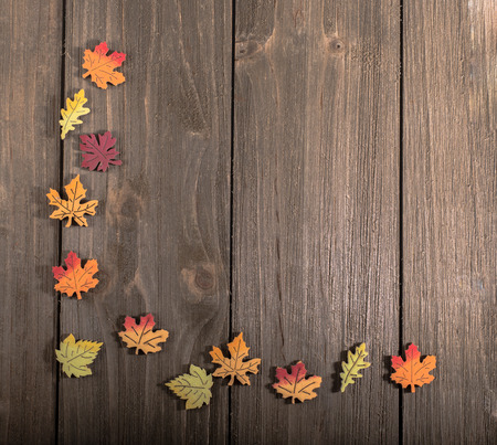 Wooden autumn leaves in a corner pattern on wood with blank spaceの写真素材