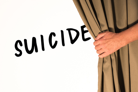 The word Suicide being revealed from behind a curtainの写真素材