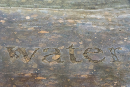 The Word Water carved into stone in a fountainの写真素材
