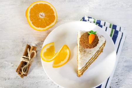 Carrot cake decorated with carrot figurine of mastic on a wooden backgroundの写真素材