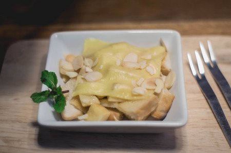 Toast topped with nuts peppermint and cheese. Extreme shallow depth of field with selective focus on toast and some blur on corner of plate.の写真素材