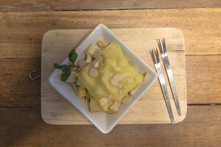 Toast topped with nuts peppermint and cheese. Extreme shallow depth of field with selective focus on toast and some blur on corner of plate.の写真素材