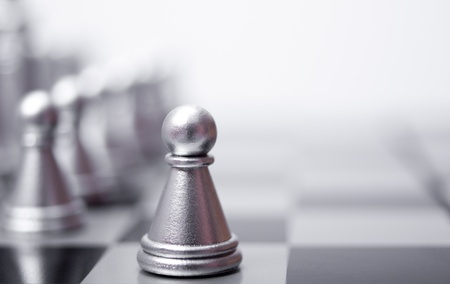 A pawn on thPawn is in front of the other pieces on the chessboard. The concept of business chessboardの写真素材