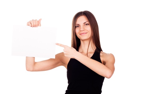 The woman in black, standing on a white background, holding a paper and shows her fingerの写真素材