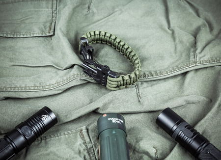 Military paracord bracelet, tactical torch and spy-glass on army-green fabricの写真素材