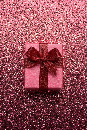 A close-up of a pink gift box adorned with a vibrant red bow, perfect for special occasions and celebrations.の素材